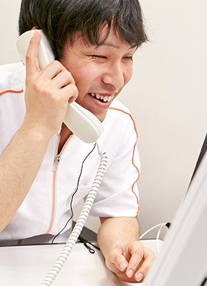 オペレーション業務の様子：笑顔で電話を受ける松崎さん