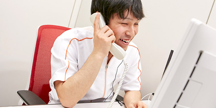 オペレーション業務の様子：笑顔で電話を受ける松崎さん